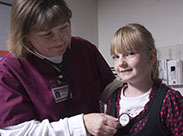 Nursing student examining a little girl