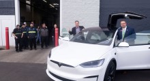 CWI President Gordon Jones gives a thumbs up as he gets into a newly acquired Tesla, watched by a group of students.