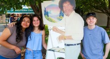Art Club students posing with a cut out of Bob Ross