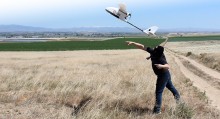 Student launching a drone in the air