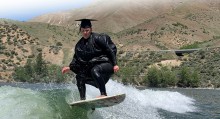 Tara Wright wake surfing at Lucky Peak in her cap and gown