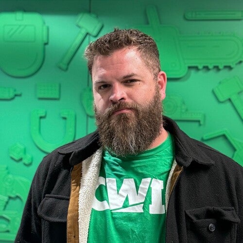 Man in front of green backdrop