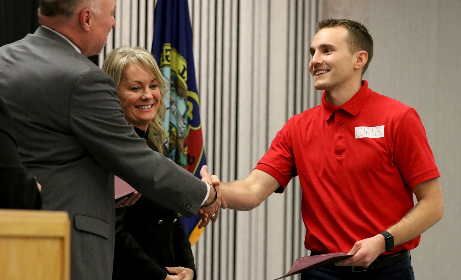 Fire Service Technology student Austin Curtis greets Kevin Platts during graduation