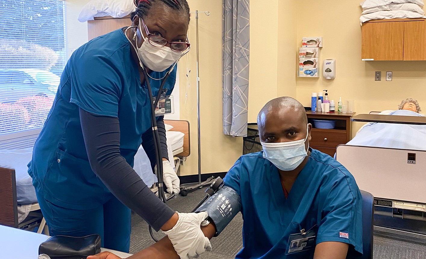 Multicultural Nursing Assistant students practicing taking blood pressure