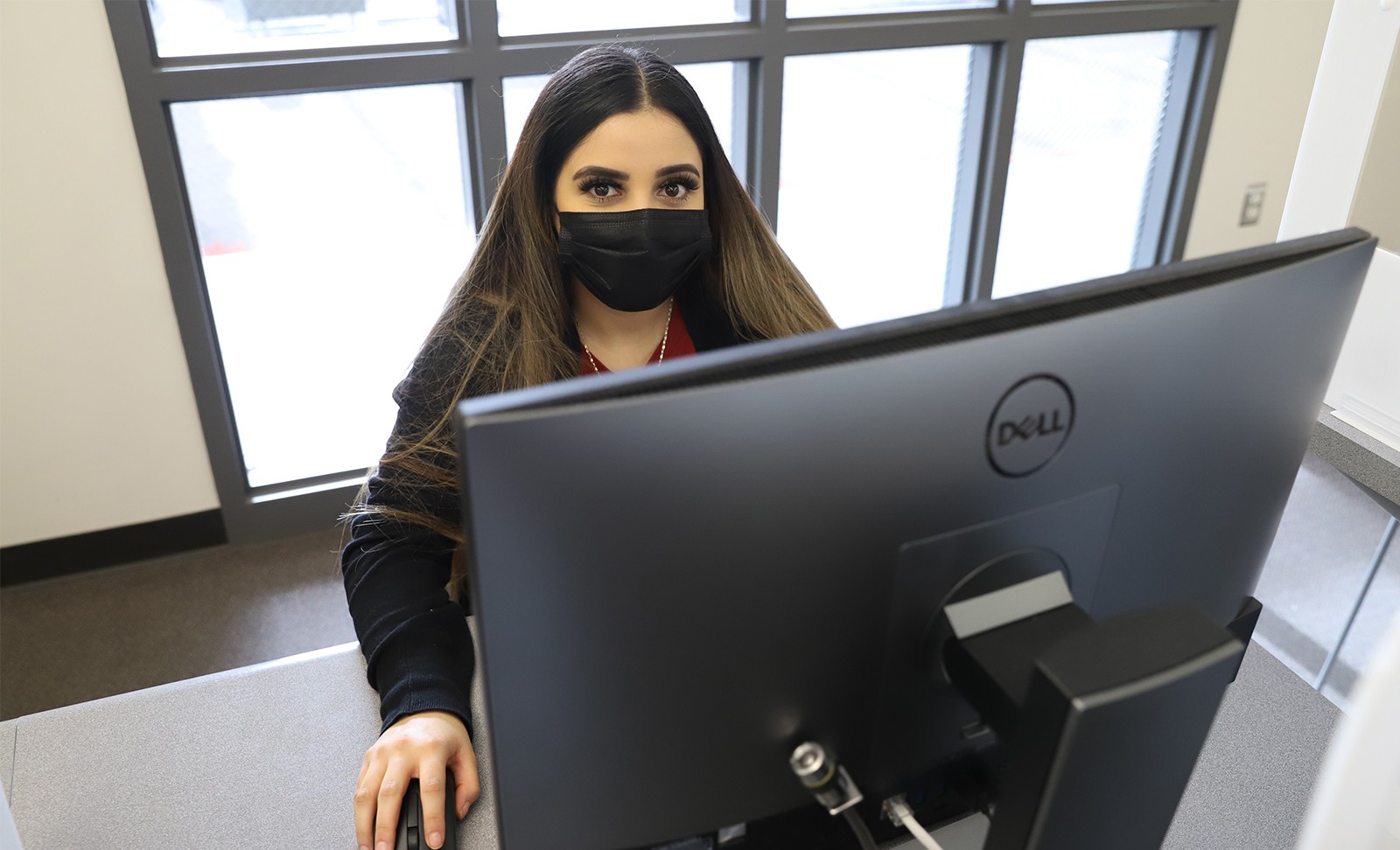 Student at a computer with a mask on