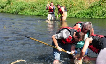 Students doing research together in a river