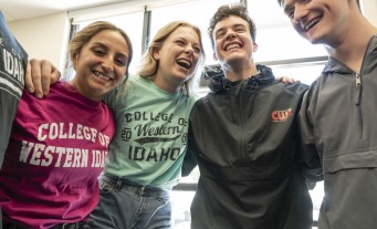 Students with arms around each other smiling and laughing