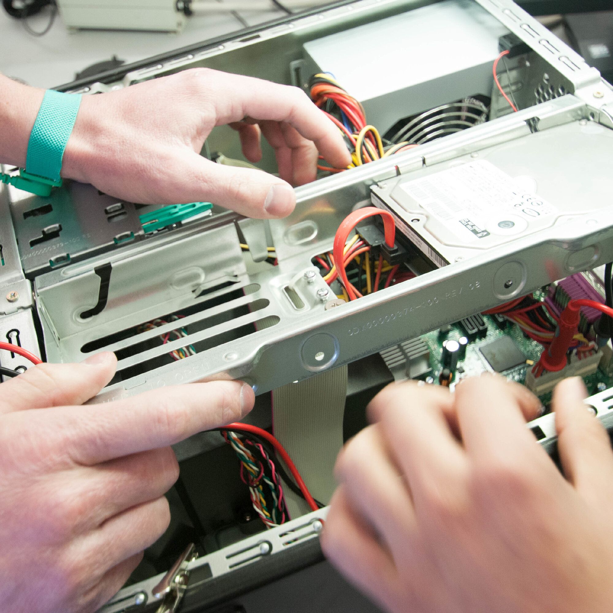 An open computer case is being held and used to teach a student about the parts.