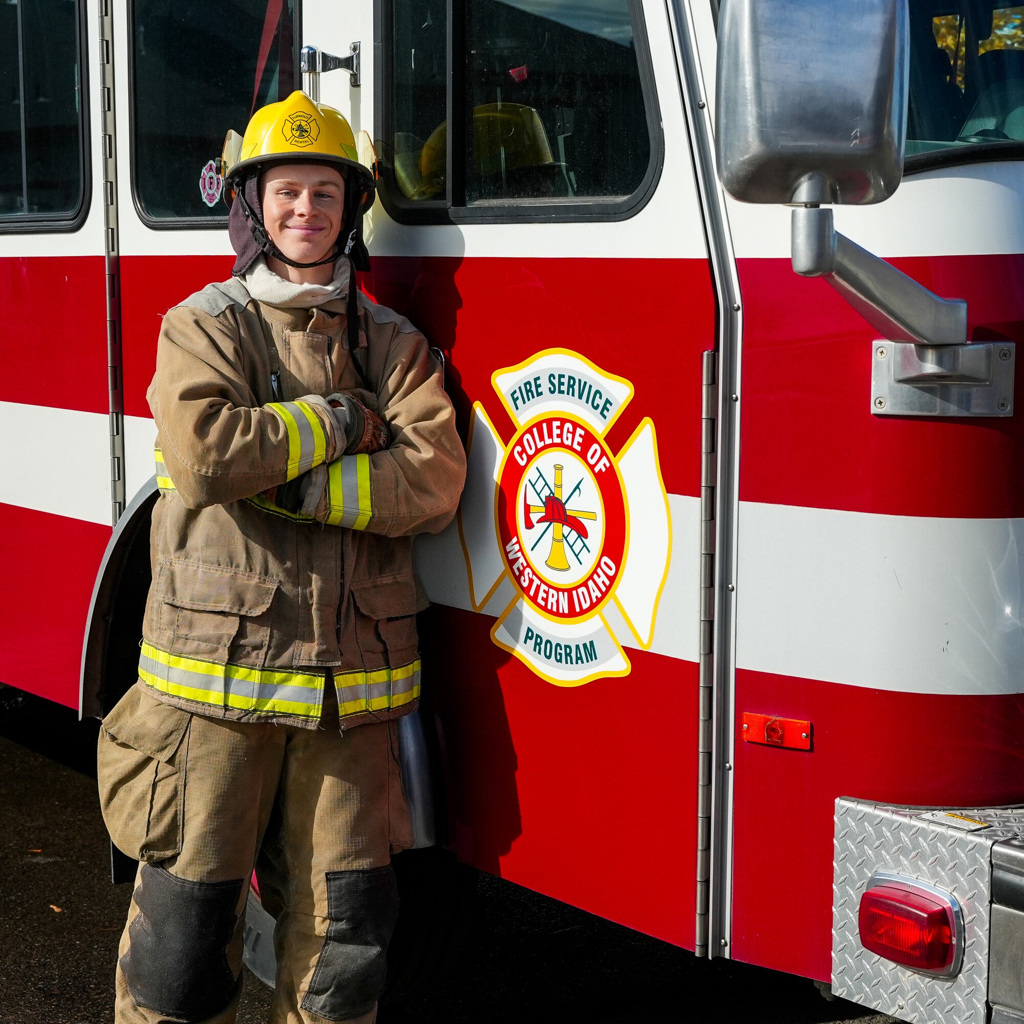 Firefighting student standing next to fire truck