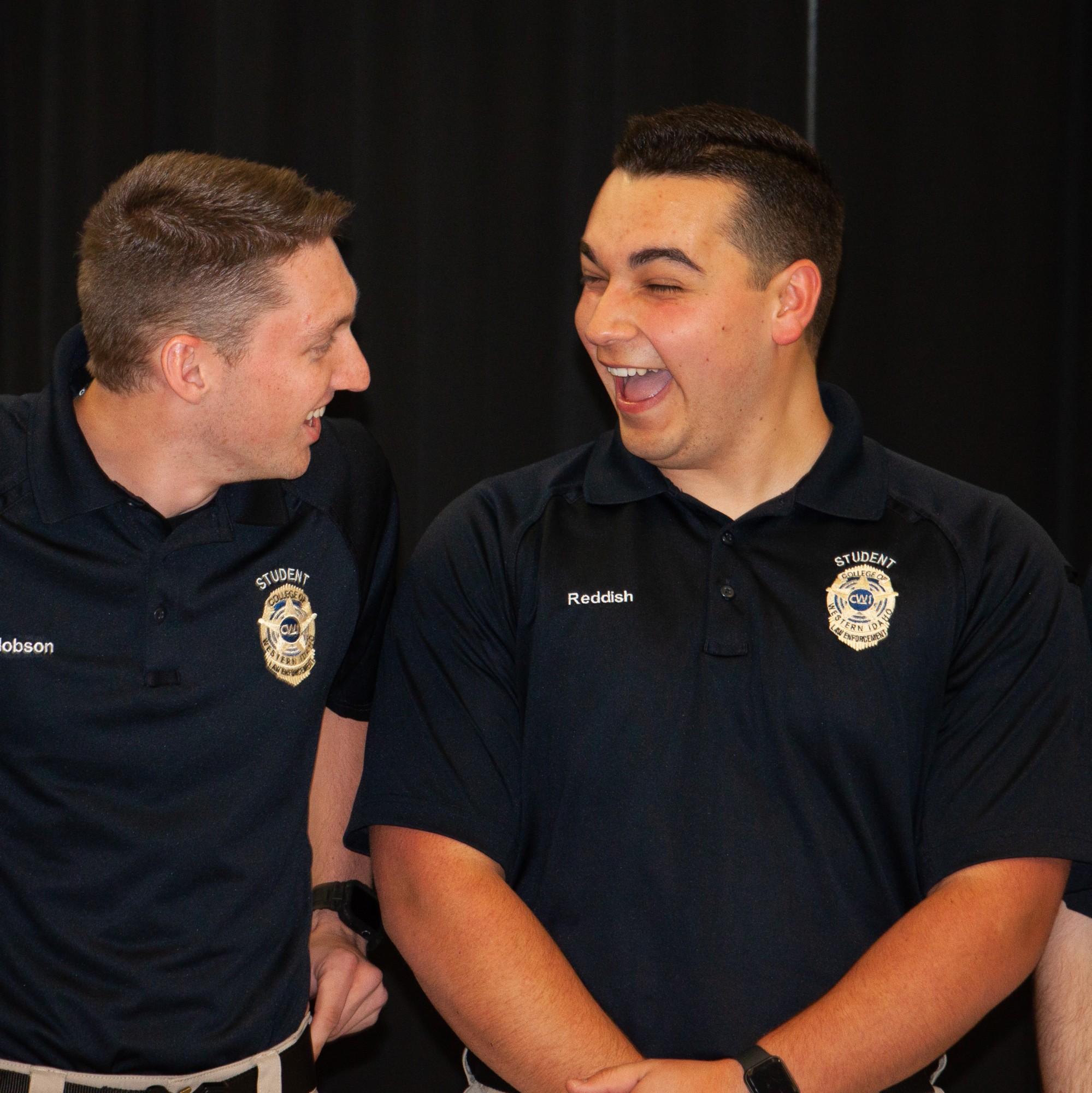 Rigdon Reddish laughing with fellow graduate at Law Enforcement Ceremony