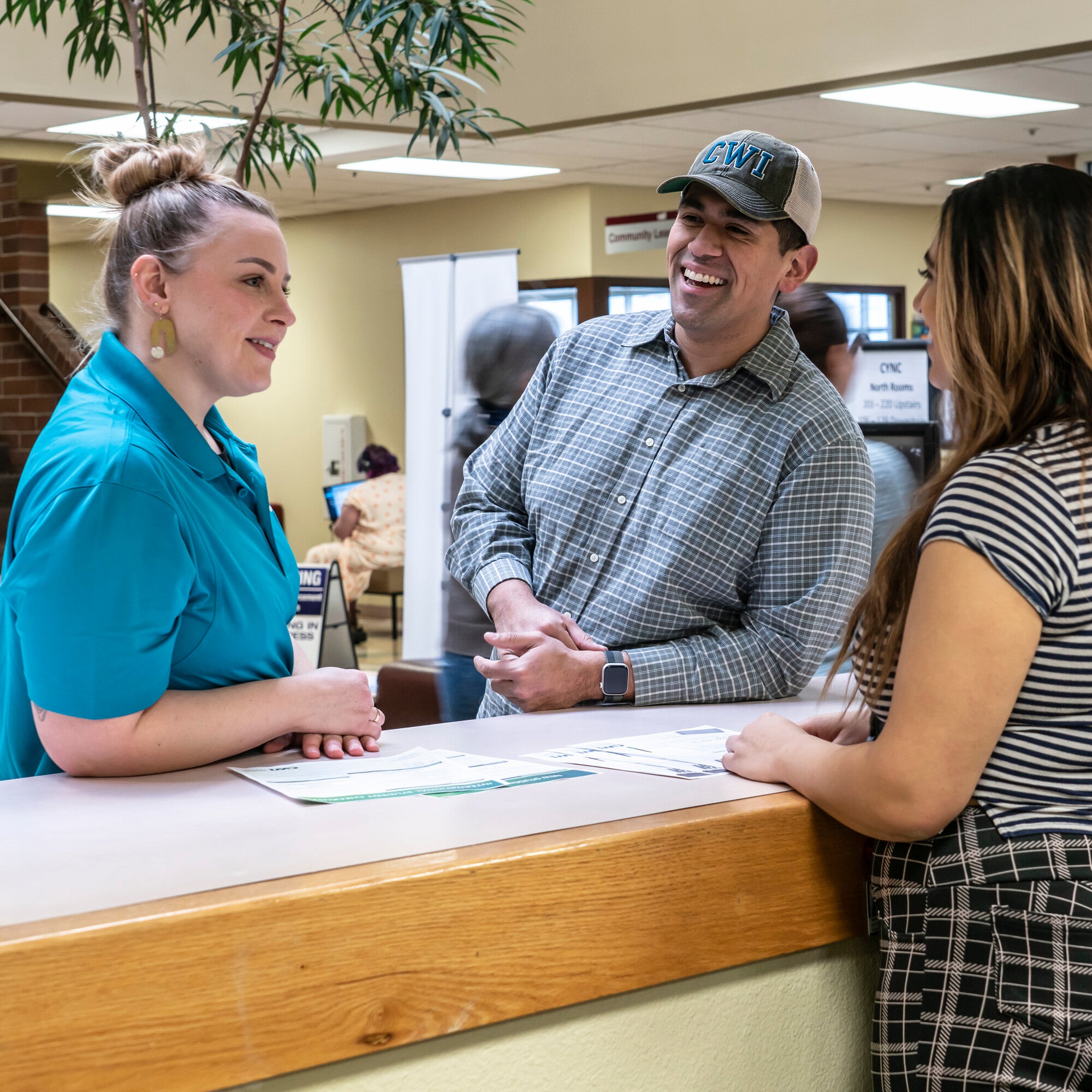 Three people chatting at a front desk