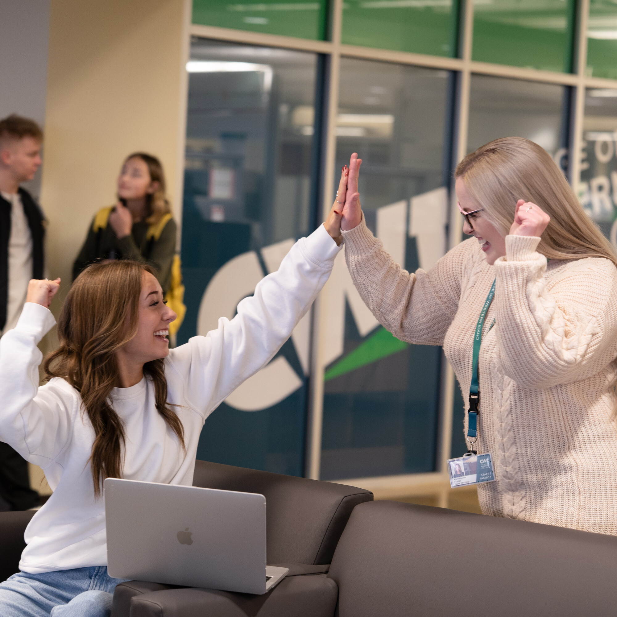 Two people high-fiving after submitting a FAFSA application