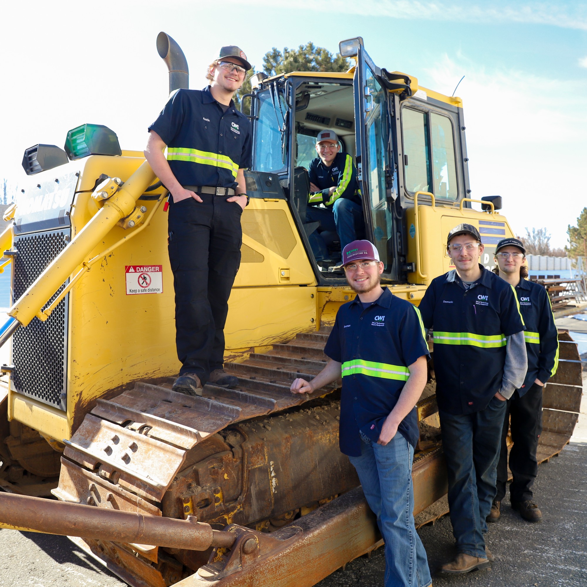 Heavy Equipment Technician students standing in front of bulldozer