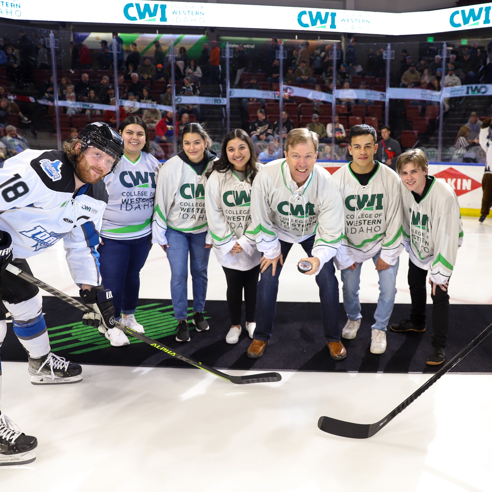 President Gordon Jones and students doing the puck drop at Steelheads game