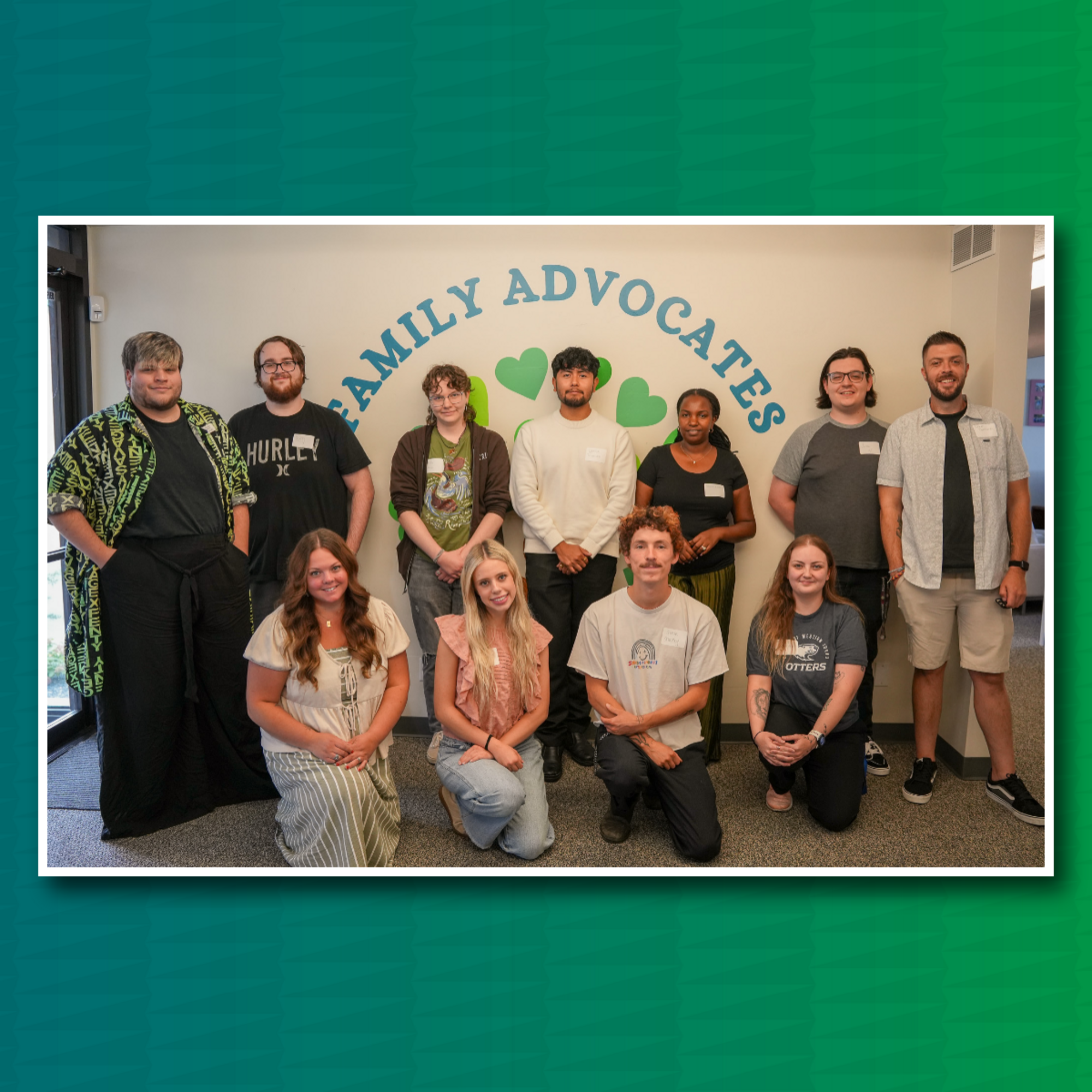 Group of 11 people stand and kneel in front of sign that says Family Advocates | Green back drop behind image