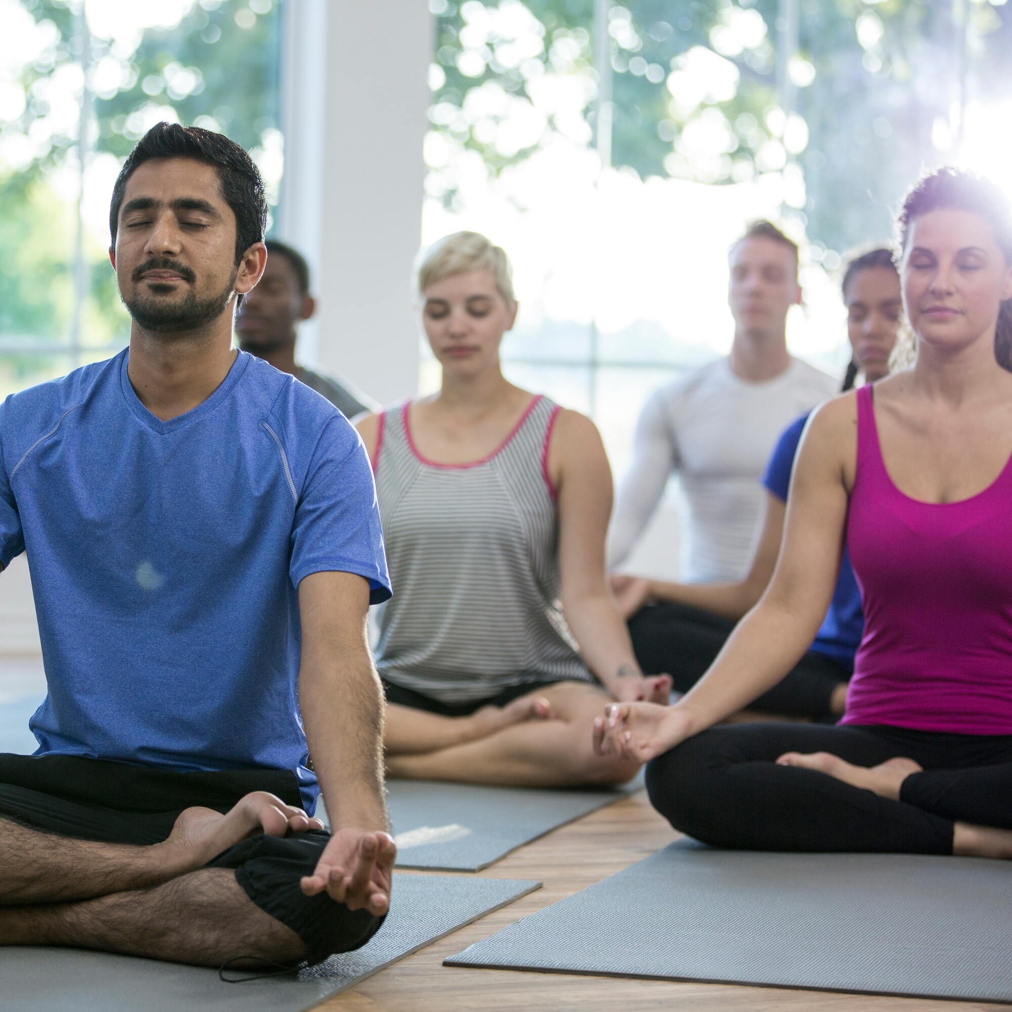 Class of yoga students seated with their eyes closed