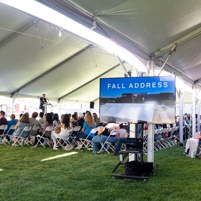 Faculty and staff sit and listen to a speaker addressing the room.