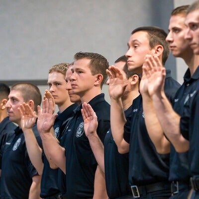 Graduates raising their hand and taking an oath