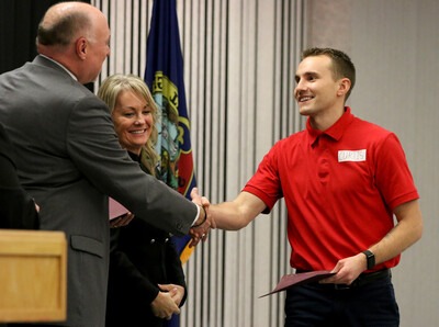 Fire Service Technology student Austin Curtis greets Kevin Platts during graduation
