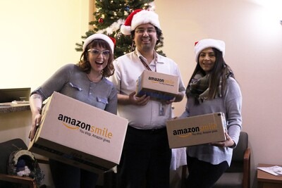 Students with amazon smile boxes in front of Christmas tree