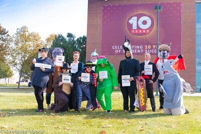 Employees dressed up in Halloween costumes outside the Nampa Campus Academic Building
