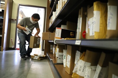 Bookstore worker packing up textbook orders to send