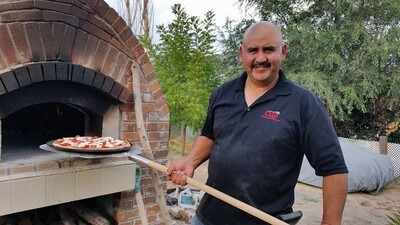 Domingo Garcia, baking pizza in brick oven