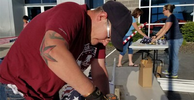 CWI student Dallas Hulsey helps assemble flags for the Eagle Field of Honor.
