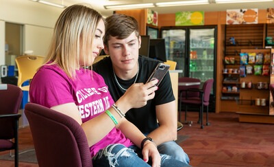 Two students looking at a cell phone 