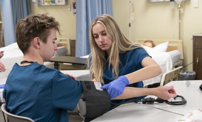 Nursing student taking blood pressure of another student