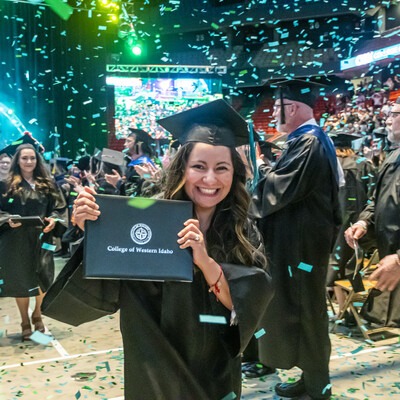 Graduate holding up degree
