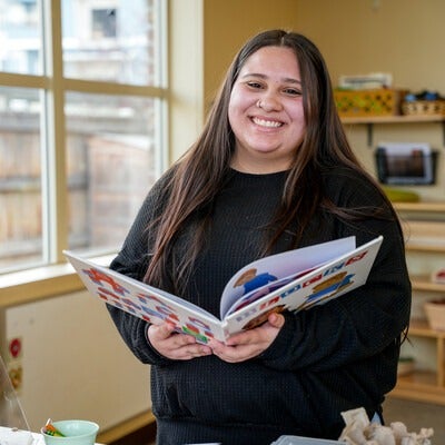 Alexus Hill reads a book in the middle of a classroom