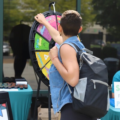Student spins prize wheel at Welcome Back Picnic