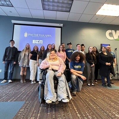 A group of students smile for a photo as they are inducted into an honors society.