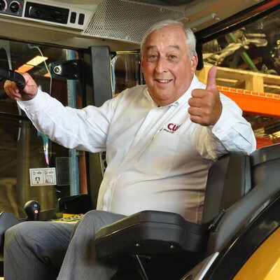 President Bert Glandon sitting in a tractor and giving a thumps up