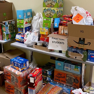 food pantry donations stacked on a table and on the floor