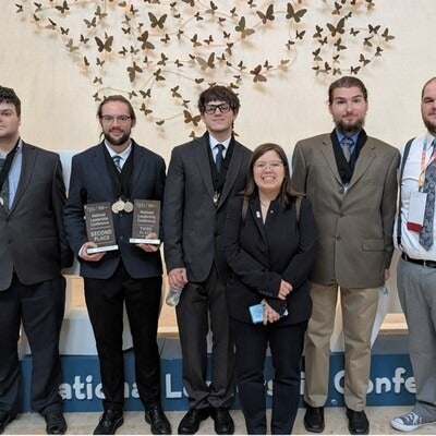 Students pose for a photo holding awards.