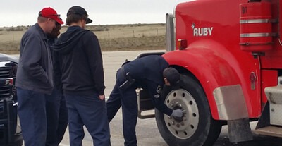 CWI students checking lug bolts on a semi truck