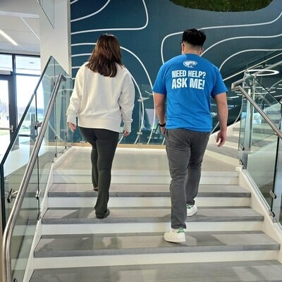 Two people walking up staircase