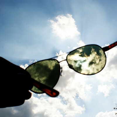 sunglasses being held up in the air