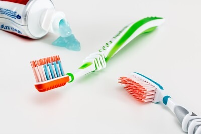 Two toothbrushes and a bottle of toothpaste