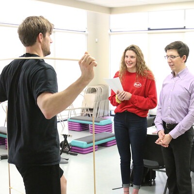 Student and instructor performing a fitness evaluation on an employee in the lab.