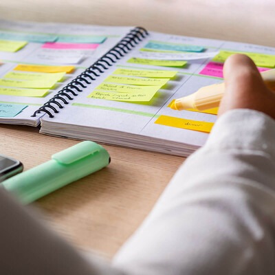 Image shows a student using a planner to get organized and prioritize tasks between school and work.
