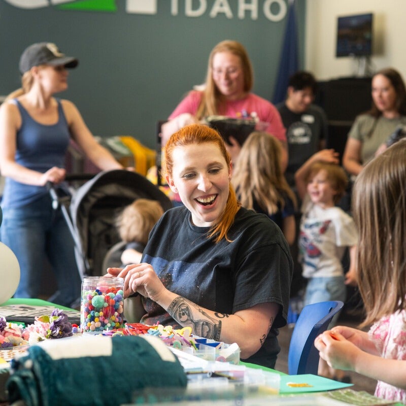 A student decorates a graduation cap at a Grad Fest.