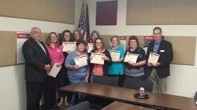 Employees standing with the Bert Glandon being recognized