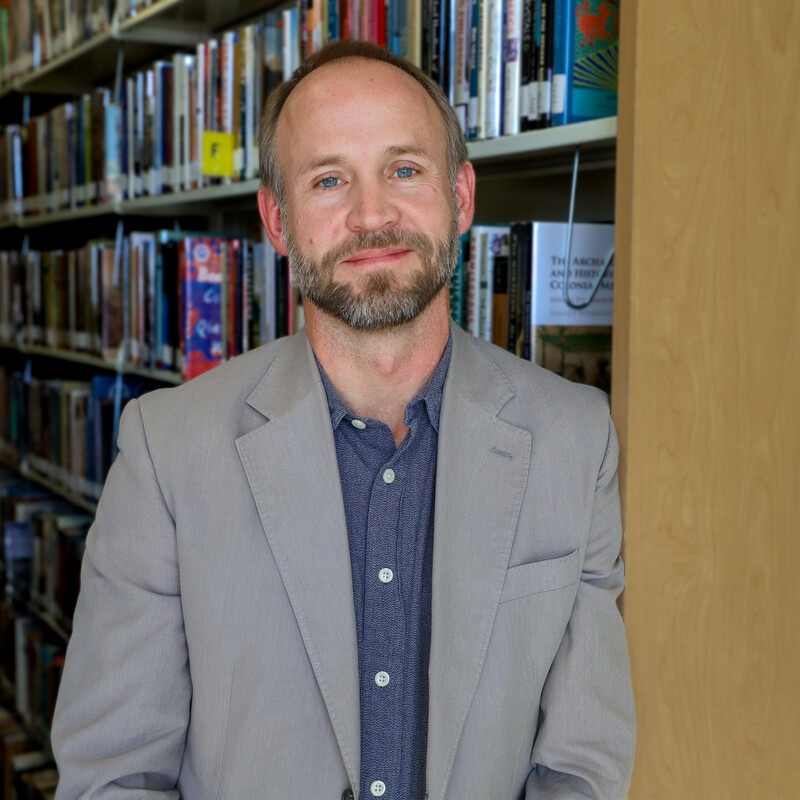 Jaren Watson leaning against bookshelf 