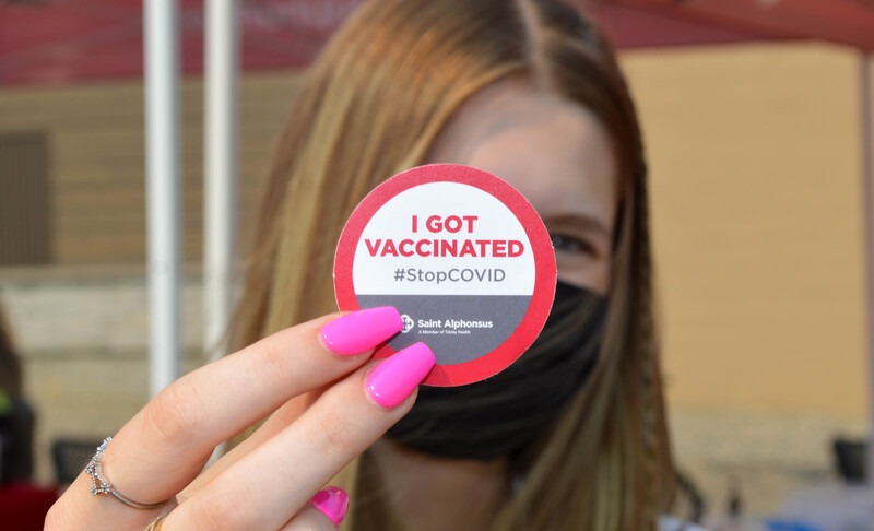 individual with a vaccination sticker