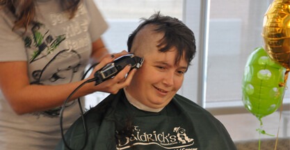 Employee getting hair shaved off