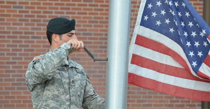 Serviceman reaching the flag