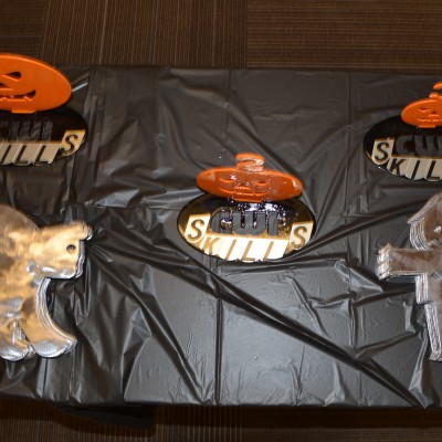 Close up of a Halloween table display with pumpkins and black table cloth.